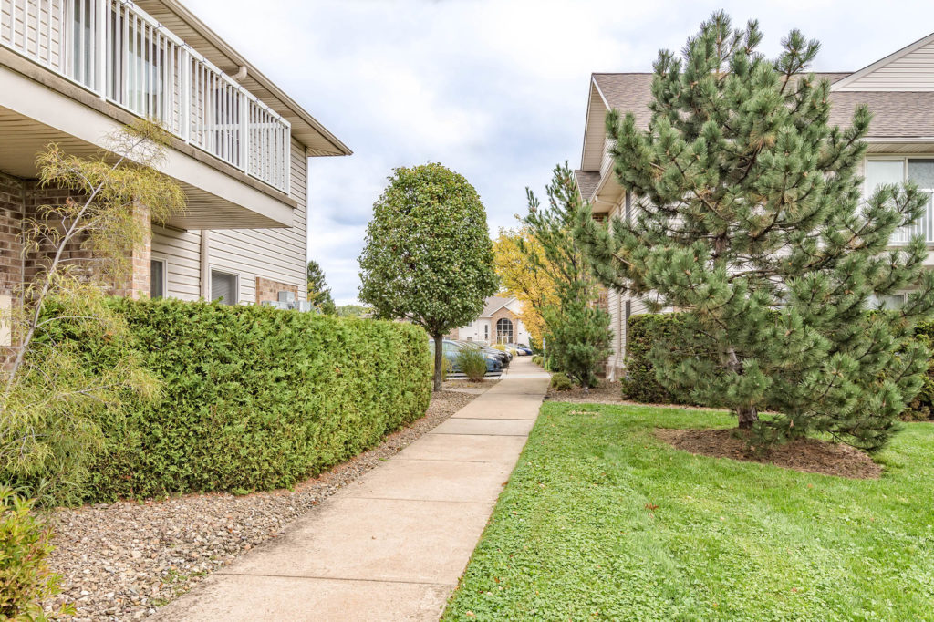 Scenic sidewalk view winding between Laurel Ridge community buildings and throughout the beautifully landscaped grounds.