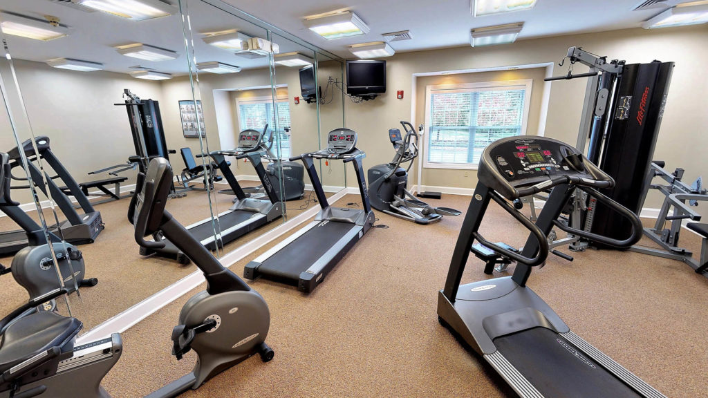 Fitness center with treadmill, stationary bike, elliptical and free weight machine at The Hammocks at Southern Hills.