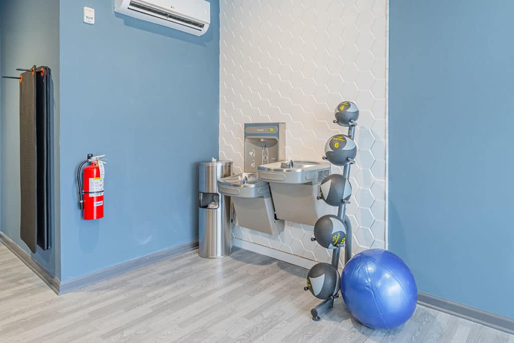 Water station and medicine balls located inside the fitness room