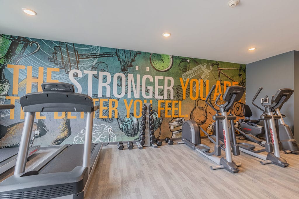 Fitness room with inspiration quote on the wall behind exercise machines