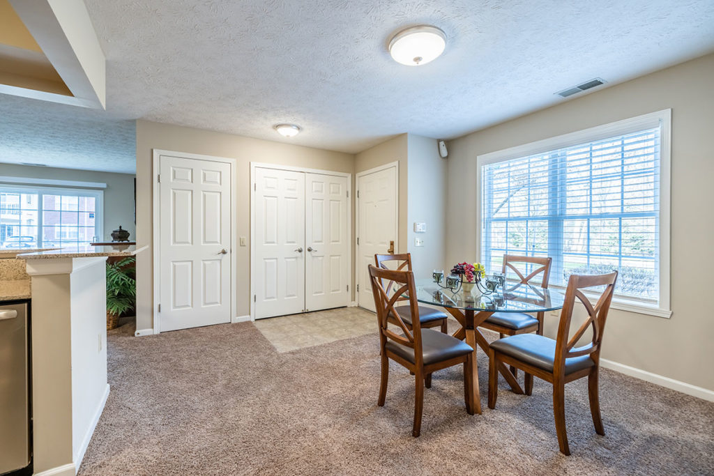 Large dining carpeted space located next to kitchen and windows for natural sunlight.