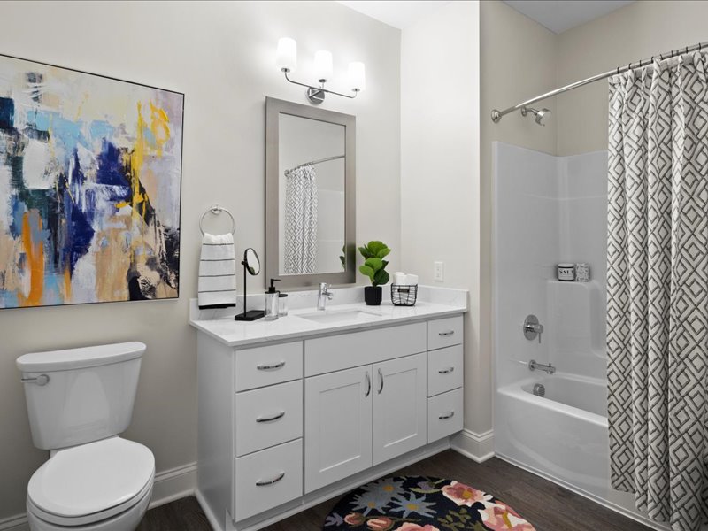 Guest bathroom with shower tub, single vanity and toilet with luxury vinyl plank flooring