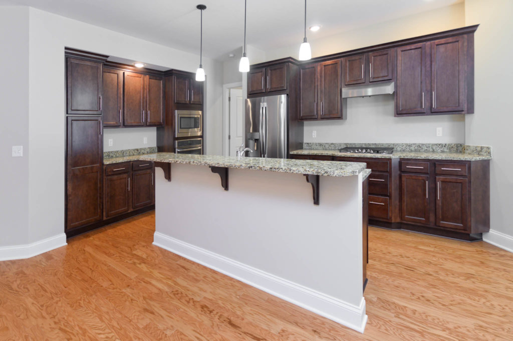Interior kitchen view of Carriage Home with dark cabinetry and marble quartz countertops
