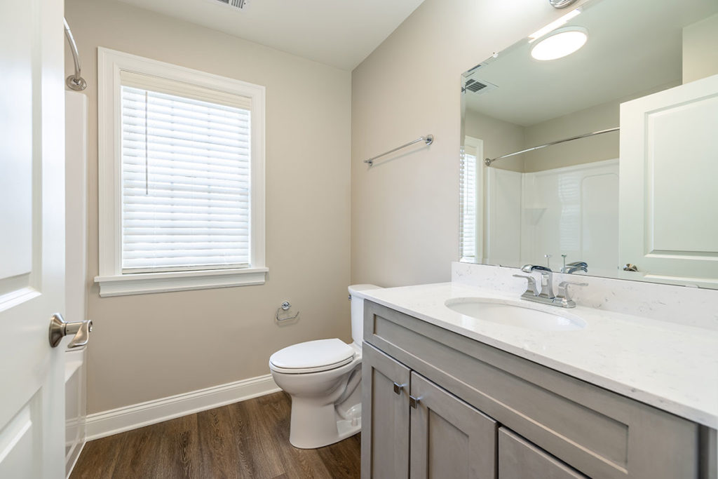 Renovated second bathroom with tub/shower, new vanity with quartz countertop and vinyl plank flooring.