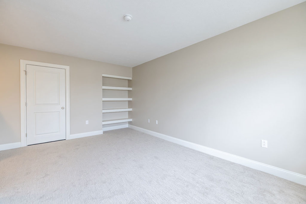 Renovated townhome bedroom or den view with interior shelving and access to additional storage room