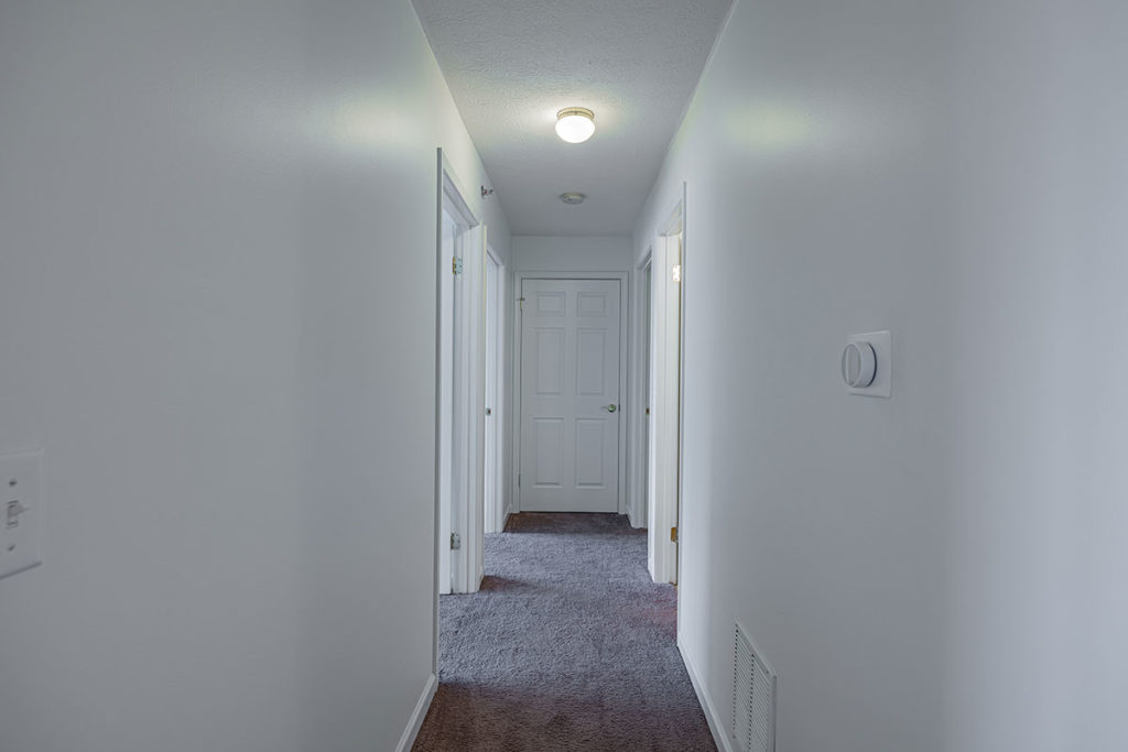 Carpeted two bedroom with den apartment hallway