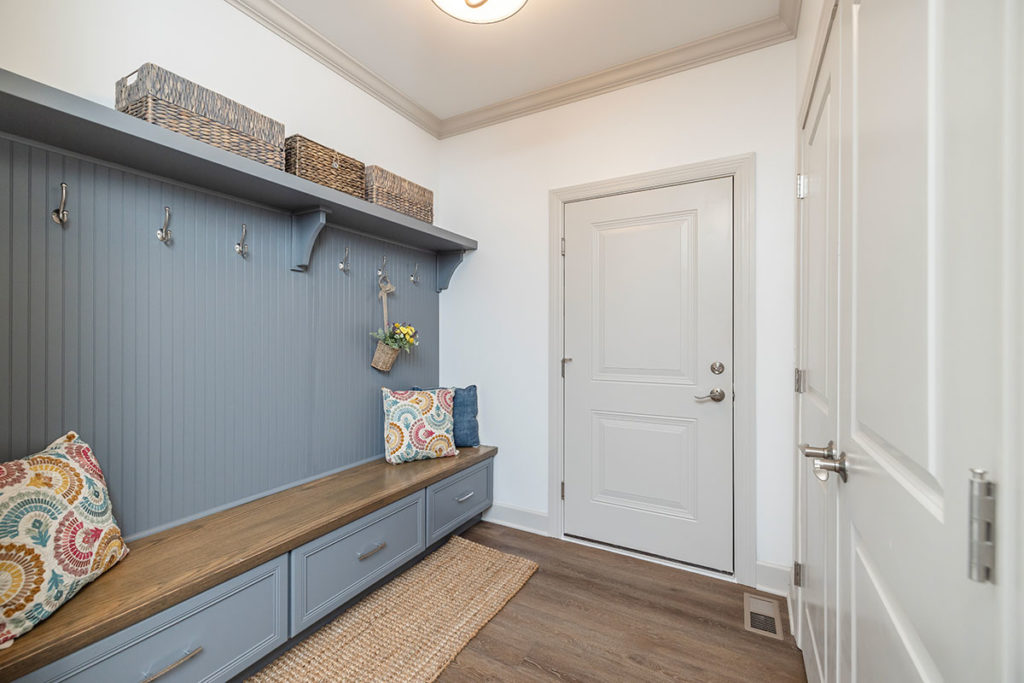 Mudroom with bench for seating, drawer space for storage and coat hooks.