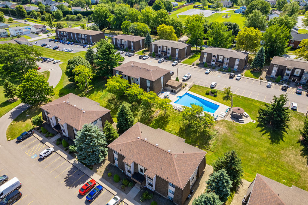 Aerial view of Alpine Village Apartments Community with views of exterior building and pool area