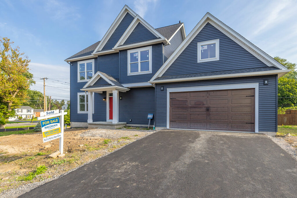 Two-story home with navy blue siding and 2-car garage at Homestead on Kreag. Lot has been sold.