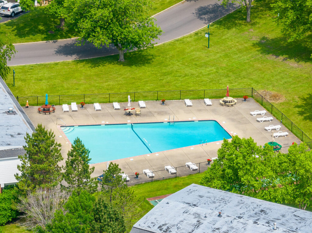 Captured from above, the aerial perspective reveals a captivating swimming pool and sundeck area. Nestled within a picturesque setting, the poolside with its inviting atmosphere and leisurely amenities.