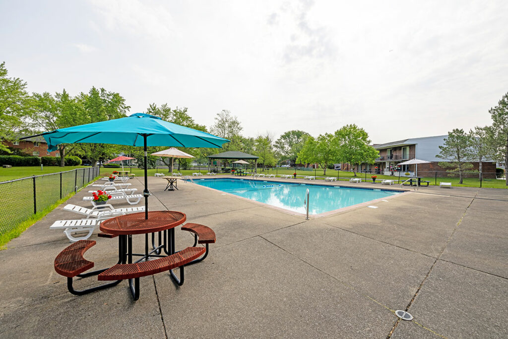Gorgeous inground swimming pool and sundeck area for residents to enjoy at Town Hall Terrace. Residents are able to use the umbrella picnic tables and sun chairs.
