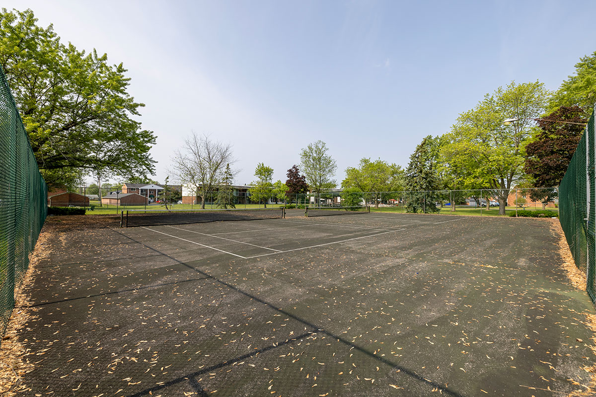 Fenced in tennis court, with two courts.