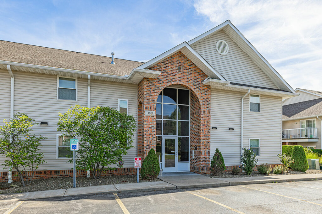 An exterior image of a building at Laurel Springs Apartments featuring a grand brick entrance with cathedral-like architecture.