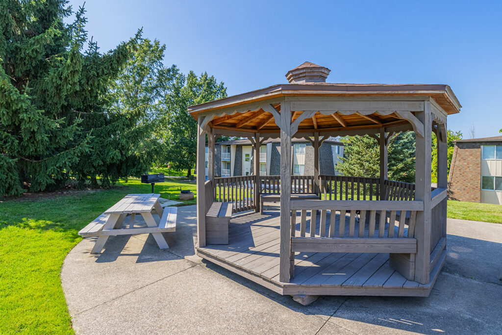 Large community gazebo and picnic area with plenty of seating located near the swimming pool