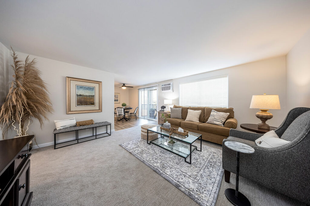 Contemporary 2 Bedroom Apartment Living Room with Adjoining Dining Area and Freshly Installed Carpeting